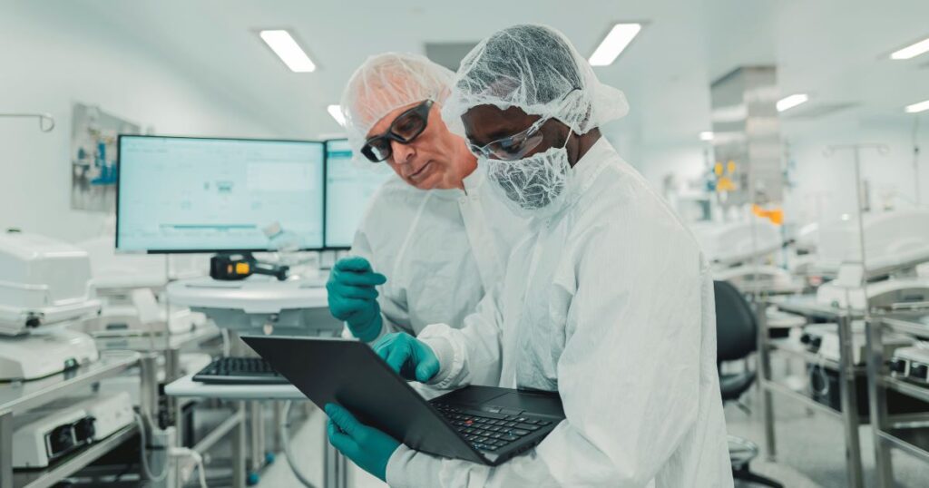 Photo of two Bristol Myers Squibb cell therapy employees wearing personal protective equipment