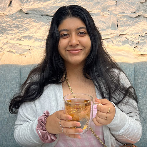 Portrait of Bindra holding a cup of tea