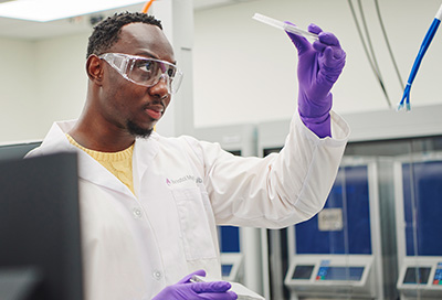 African American scientist looking at a test tube