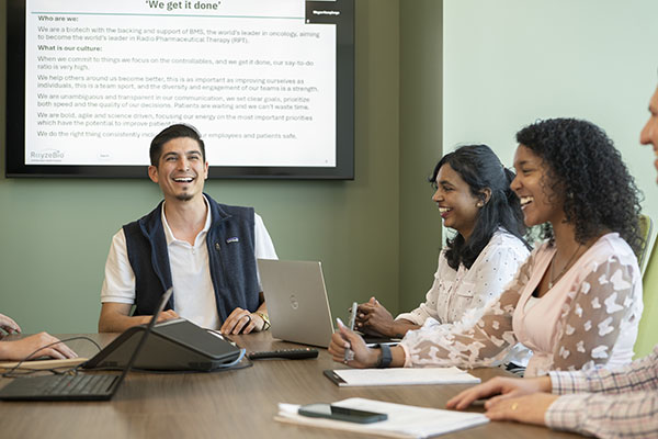 Photo of employees laughing in a conference room